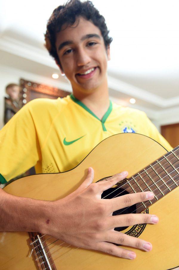 Joao de Assis, who was born with 12 fingers, plays guitar in his home in Brasilia, on June 21, 2014. (AFP PHOTO/ EVARISTA SA)