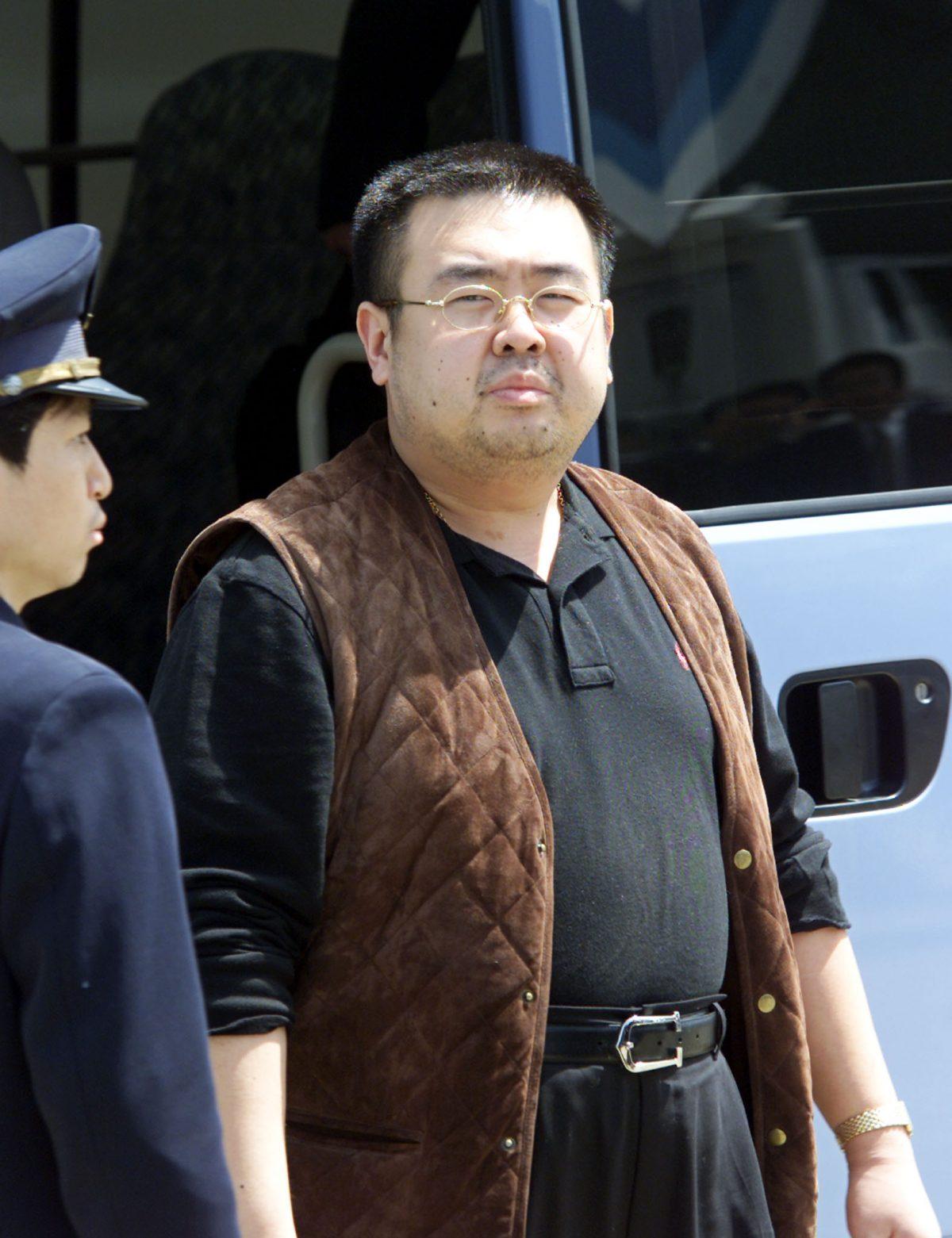Escorted by an immigration officer, a man believed to be Kim Jong-Nam, son of North Korean leader Kim Jong-Il, gets off a bus to board an ANA905 (All Nippon Airways) airplane at Narita airport near Tokyo, on May 4, 2001. (Toshifumi Kitamura/AFP/Getty Images)