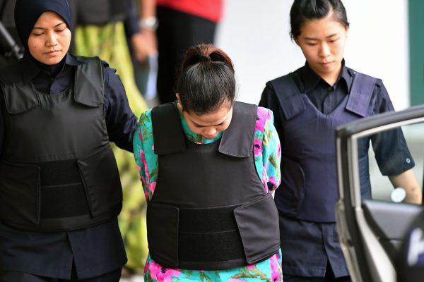 Indonesian defendant Siti Aisyah is escorted by police personnel following her appearance at the Malaysian Chemistry Department in Petaling Jaya, outside Kuala Lumpur on Oct. 9, 2017, as part of the ongoing trial for her alleged role in the assassination of Kim Jong-Nam, the half-brother of North Korean leader Kim Jong-Un. (Mohd Rasfan/AFP/Getty Images)