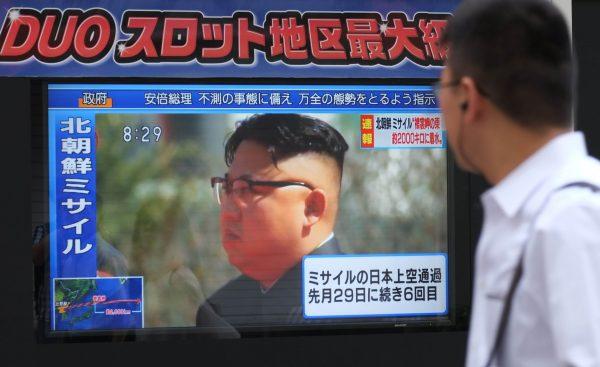 Pedestrians walk past a television screen broadcasting a news report showing North Korean leader Kim Jong-Un, in Tokyo on September 15, 2017, following a North Korean missile test that passed over Japan. (Kazuhiro Nogi/AFP/Getty Images)