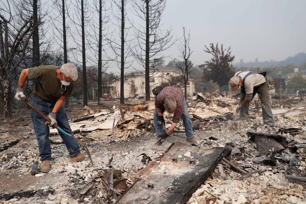 A group of retired police officers works through the ruins to look for a police badge for fellow retired officer Tom Francois after his home was destroyed by the Tubbs Fire in Santa Rosa. (REUTERS/Stephen Lam)
