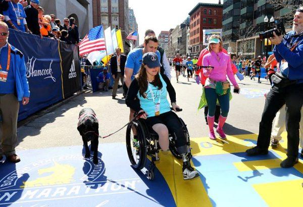 Boston Marathon bombing survivors Patrick Downes and Jessica Kensky celebrate at the finish line with their dog Rescue after Downes completed the 120th Boston Marathon on April 18, 2016 in Boston, Massachusetts. (Maddie Meyer/Getty Images)