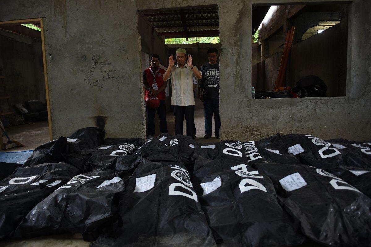An imam prays in front of body bags containing the remains of victims of Marawi siege prior to a mass burial at a funeral parlor in Iligan City, in southern island of Mindanao on July 24, 2017, as the fighting between government troops and Muslim terrorists entered its second month.<br/>The government is continuing to fight ISIS terrorists in the southern city of Marawi, a day after Congress voted to extend martial law over the southern Philippines until the end of the year. (TED ALJIBE/AFP/Getty Images)