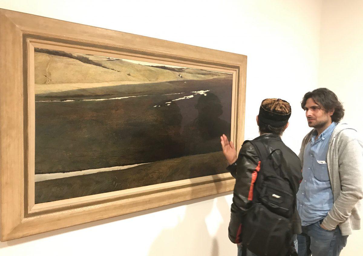 Artists Carlos Madrid (L) and Jordan Sokol talk about Andrew Wyeth's painting, "Hoffman’s Slough," 1947, tempera on hardboard panel, Everson Museum of Art, Syracuse, N.Y. Bequest of Jane R. Meyer, in The Brandywine River Museum of Art in Chadds Ford, Pennsylvania, on Sept. 2, 2017. (Milene Fernandez/The Epoch Times)