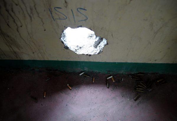 Empty shells and cigarette butts are seen under a hole where snipers from the pro-Islamic State militant groups used to position themselves inside a house in the war-torn Marawi city, southern Philippines Oct. 19, 2017. (Reuters/Romeo Ranoco)
