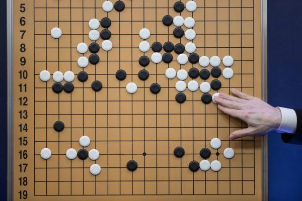 A commentator in a media room positions pieces forming a replica of a game between 'Go' player Lee Se-dol and a Google-developed AI in Seoul on March 13, 2016. (Ed Jones/AFP/Getty Images)