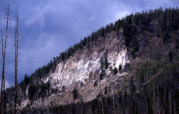 Tuff Cliff in Yellowstone National Park. The different color on the cliff's face shows the layer of volcanic material from the previous massive explosion of the Yellowstone supervolcano. (Jim Peaco/NPS)