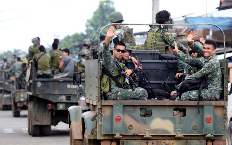 Member of the Philippine Marine Battalion Landing Team (MBLT) wave at residents and motorists while in a military truck as they travel their way back from their five-month combat duty against pro-ISIS terrorist groups, a few days after President Rodrigo Duterte announced the Liberation of Marawi city, southern Philippines on Oct. 21, 2017. (REUTERS/Romeo Ranoco)