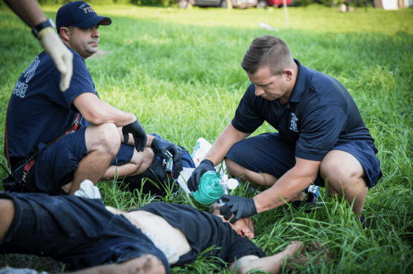 Local police and paramedics help a man who is overdosing in Montgomery County, Ohio, on Aug. 3, 2017. (Benjamin Chasteen/The Epoch Times)