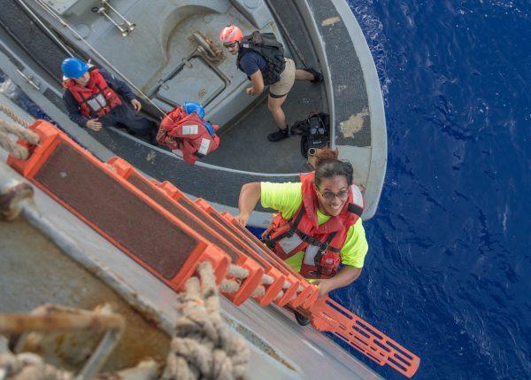 Tasha Fuiaba, an American mariner who had been sailing for five months on a damaged sailboat, climbs the ladder to board the USS Ashland. (U.S. Navy photo by Mass Communication Specialist 3rd Class Jonathan Clay)