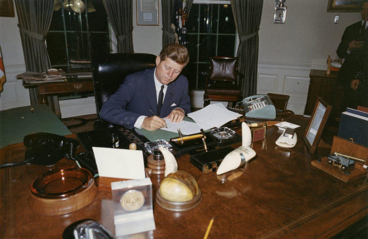 U.S. President John F. Kennedy signs a proclamation for the interdiction of the delivery of offensive weapons to Cuba during the Cuban missile crisis, at the White House in Washington, D.C. Oct. 23, 1962. (Cecil Stoughton/The White House/John F. Kennedy Presidential Library/File Photo via REUTERS)