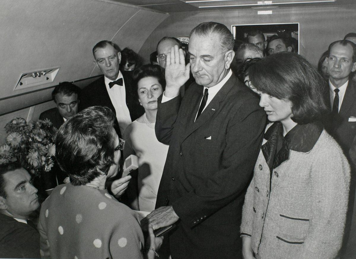U.S. Vice President Lyndon Baines Johnson (C) takes the presidential oath of office from Judge Sarah T. Hughes (2nd from L) as President John F. Kennedy's widow first lady Jacqueline Bouvier Kennedy (2nd from R) stands at his side aboard Air Force One at Love Field in Dallas, Texas just two hours after Kennedy was shot in this Nov. 22, 1963. (JFK Library/Cecil Stoughton/The White House/File Photo via REUTERS)