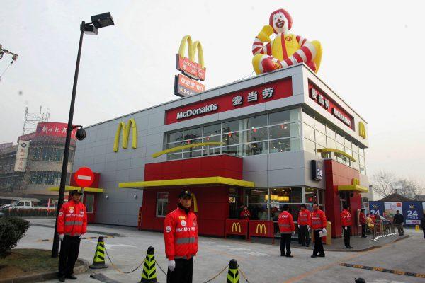  Chinese staff wait for the first customers at the opening of a McDonald's drive-thru outlet built next to a gas station in Beijing on Jan. 19, 2007. (STR/AFP/Getty Images)