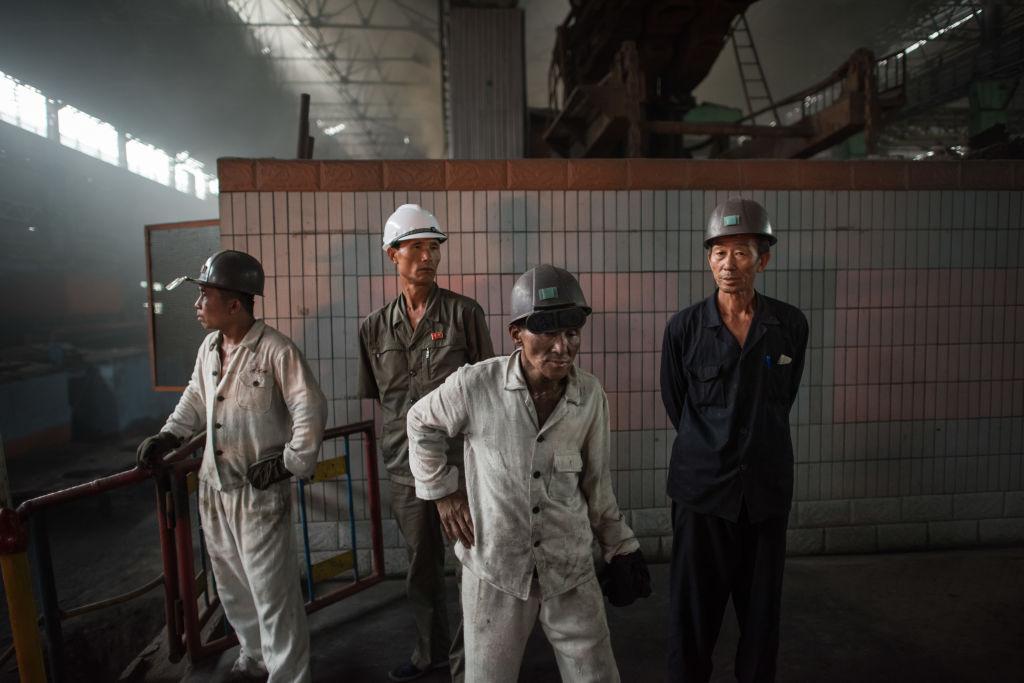 In a photo taken on July 22, 2017 workers watch as molten steel is transfered from a furnace during production at the Chollima Steel Complex, south-west of Pyongyang. Many workers are paid trivial salaries as food prices double or triple. (ED JONES/AFP/Getty Images)