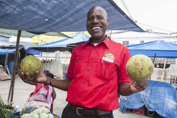 Local driver Willie Burgess shows off fresh coconuts from a stand at the Ocho Rios market. (Annie Wu/The Epoch Times)