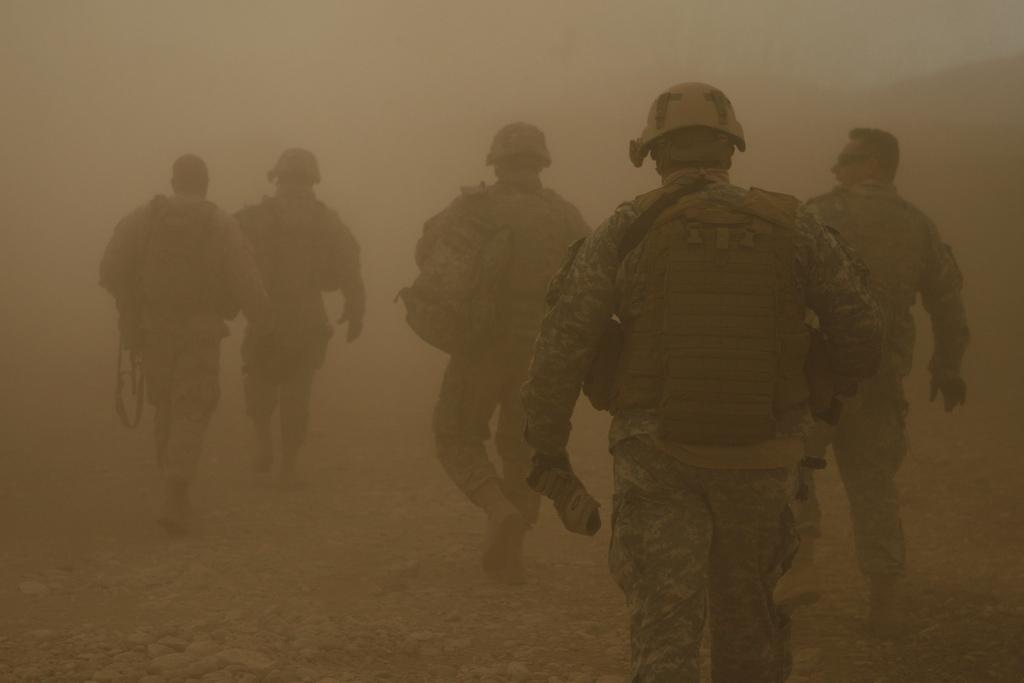 Soldiers and Marines walk through rotor wash from a UH-60 Blackhawk Helicopter as they move toward a Forward Operating Base in the village of Darrah-I-Bum, Badghis Province, Afghanistan, on Jan. 5, 2011. (Sgt. Brian Kester/U.S. Marines)