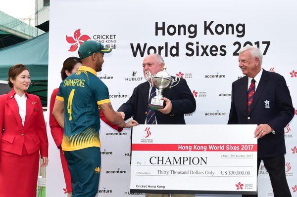 South Africa’s team Captain Aubrey Swanepeol receives the Hong Kong World Cricket Sixes trophy and winner’s check from Mike Gatting OBE, Chairman MCC World Cricket together with Rodney Miles President HK Cricket, following completion of the 2 day tournament at KCC on Sunday Oct 29, 2017 (Bill Cox/Epoch Times).