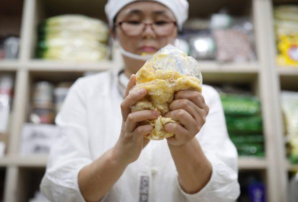 North Korean defector Hong Eun-hye demonstrates how North Korean people make rice cakes with corn powder at her North Korean food store in Seoul, South Korea, September 28, 2017. (Reuters/Kim Hong-Ji)