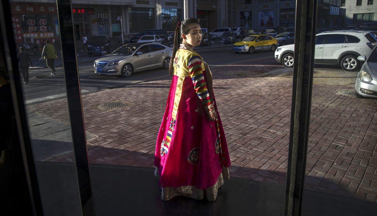 A North Korean restaurant worker tries to attract customers in the border city of Dandong, Liaoning province, northern China across the Yalu River from the border city of Sinuiju, North Korea on May 23, 2017 in Dandong, China. Reports from inside China reveal North Korean workers are being forced out of the country. (Kevin Frayer/Getty Images)