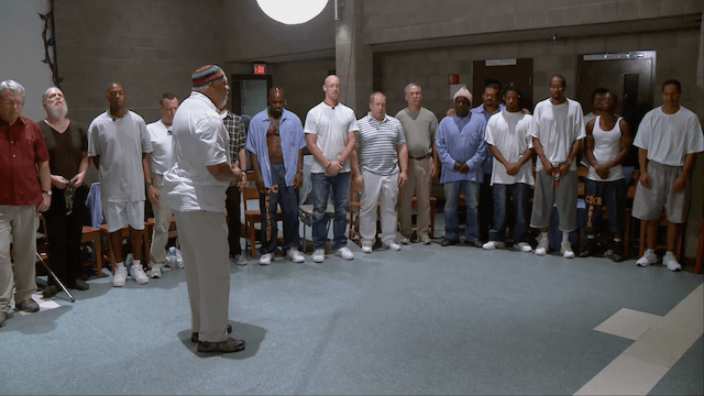 Mankind Project weekend leader and elder James McLeary leading Folsom Prison inmates and free men in a unifying African call-and-response ritual in "The Work." (SXSW Film Festival)