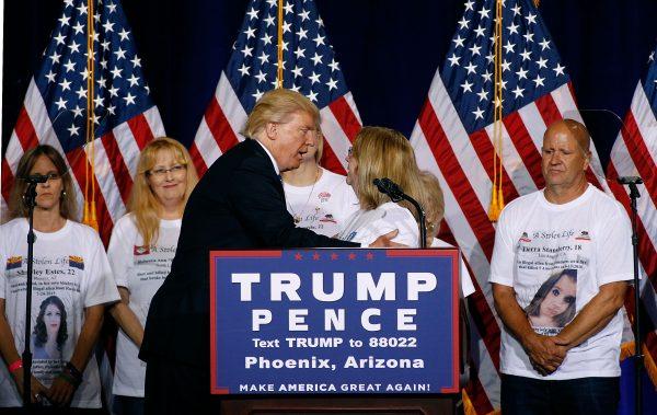 Republican presidential nominee Donald Trump shares the stage with parents whose family members were killed by illegal immigrants. Trump outlined his immigration priorities at the rally in Phoenix on Aug. 31, 2016. (Ralph Freso/Getty Images)