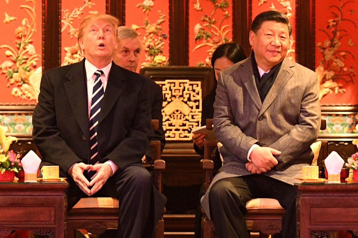 President Donald Trump looks up as he sits beside Chinese leader Xi Jinping during a tour of the Forbidden City in Beijing on Nov. 8, 2017. (Jim Watson/AFP/Getty Images)