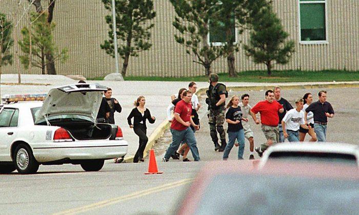 Students run from Columbine High School under cover from police after two masked teens on a "suicide mission" stormed the school, executing fellow students before turning guns on themselves in Littleton, Colo. on April 20, 1999. (Mark Leffingwell/Getty Images)