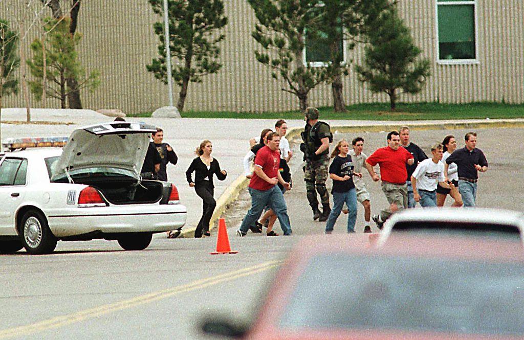 Students run from Columbine High School in Littleton, Colo., on April 20, 1999, after two masked teens on a "suicide mission" stormed the school and blasted fellow students with guns and explosives before turning the weapons on themselves. (Mark Leffingwell/AFP/Getty Images)