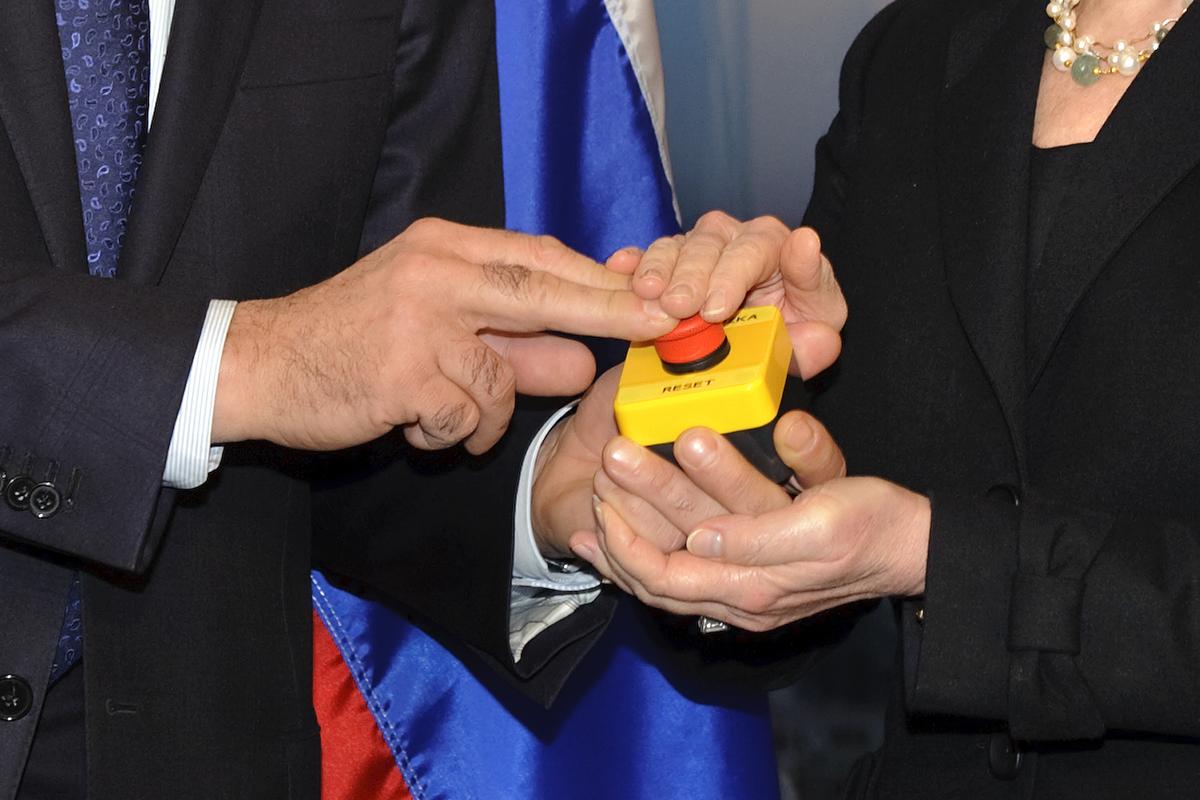 The hands of U.S. Secretary of State Hillary Clinton and Russian Foreign Minister Sergei Lavrov rest on a red button marked "reset" in English and "overload" in Russian, which U.S. Secretary of State Hillary Clinton handed to Russian Foreign Minister Sergei Lavrov during a meeting on March 6, 2009, in Geneva. (FABRICE COFFRINI/AFP/Getty Images)