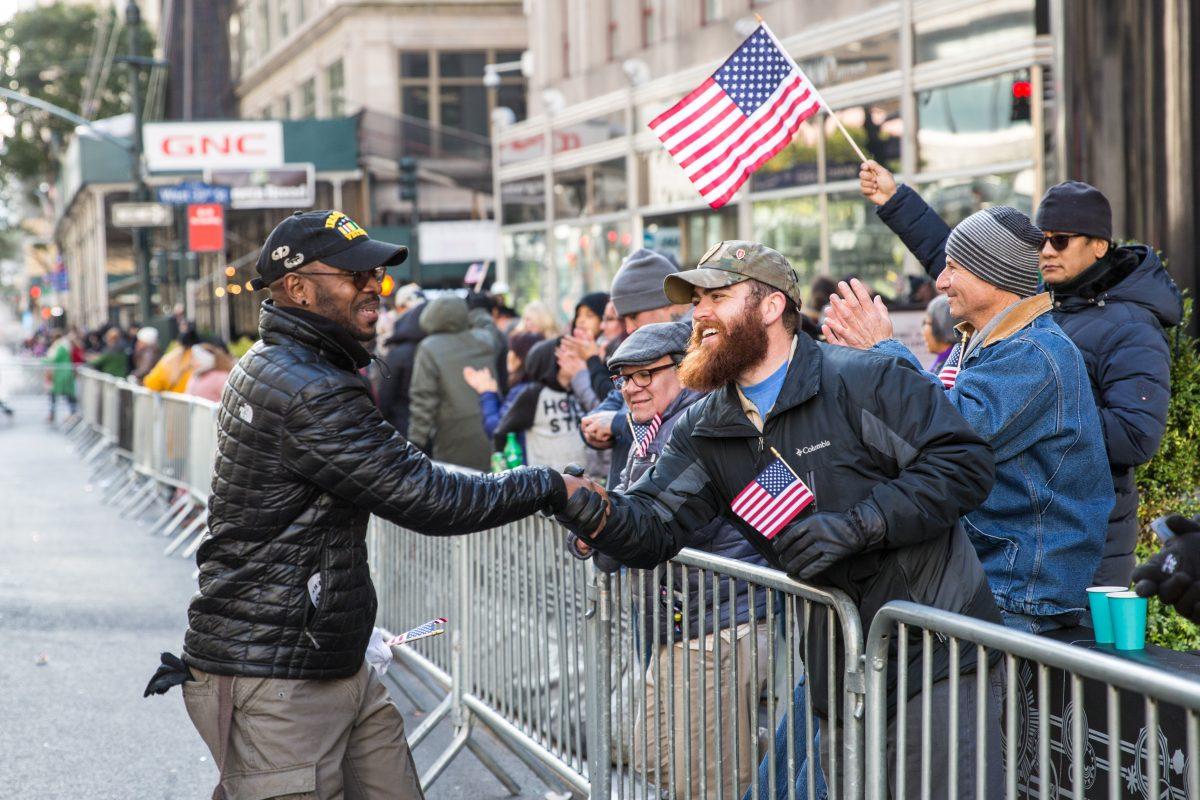 Two Veterans shake hands during the Veterans Day Parade in New York on Nov. 11, 2017. The parade is the the largest Veterans Day event in the nation, as this year's parade featured thousands of marchers from military units, civic and youth groups, businesses and high school bands from across the country and veterans of all eras. (Benjamin Chasteen/The Epoch Times)
