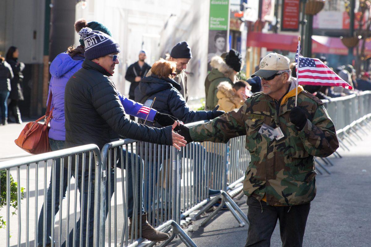 A veteran greets spectators during the Veterans Day Parade in New York on Nov. 11, 2017. The parade is the the largest Veterans Day event in the nation, as this year's parade featured thousands of marchers from military units, civic and youth groups, businesses and high school bands from across the country and veterans of all eras. (Benjamin Chasteen/The Epoch Times)