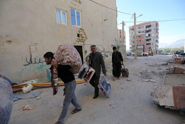 People carry their belongings following an earthquake in Sarpol-e Zahab county in Kermanshah, Iran November 13, 2017. (REUTERS/Tasnim News Agency)