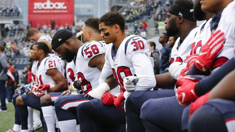 Members of the Houston Texans, including Kevin Johnson #30 and Lamarr Houston #58, kneel during the national anthem before the game at CenturyLink Field in Seattle, Wash., on Oct. 29, 2017. (Jonathan Ferrey/Getty Images)