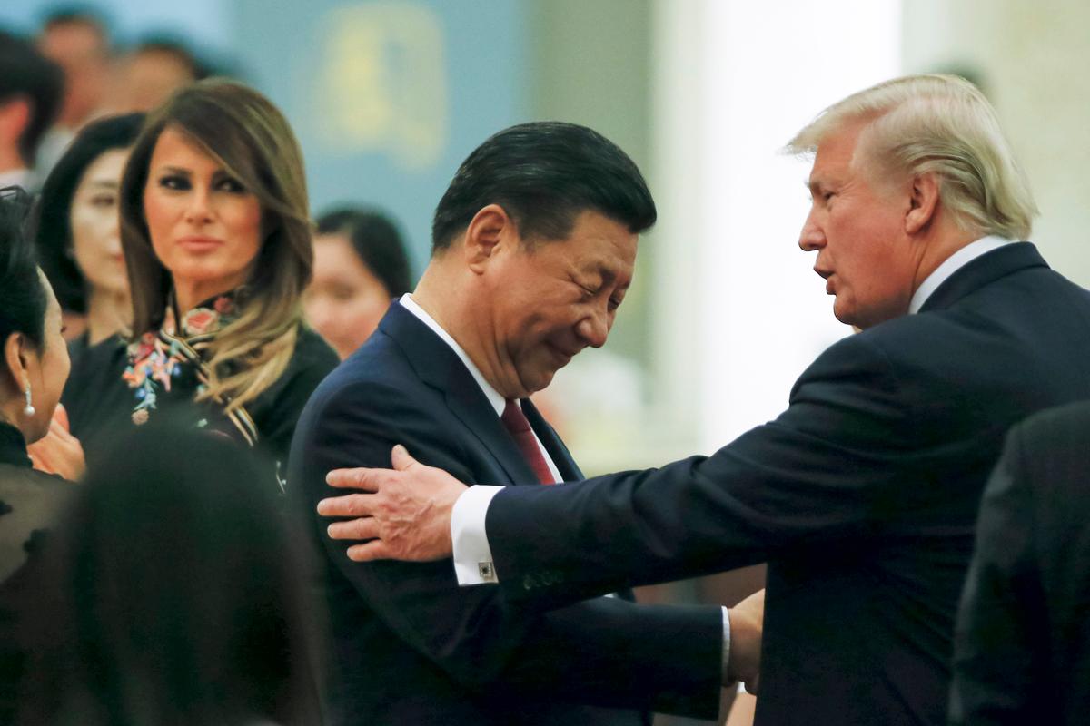 Chinese leader Xi Jinping and U.S. President Donald Trump shake hands as first lady Melania Trump looks on before a state dinner at the Great Hall of the People in Beijing, China on Nov. 9, 2017. (Thomas Peter - Pool/Getty Images)