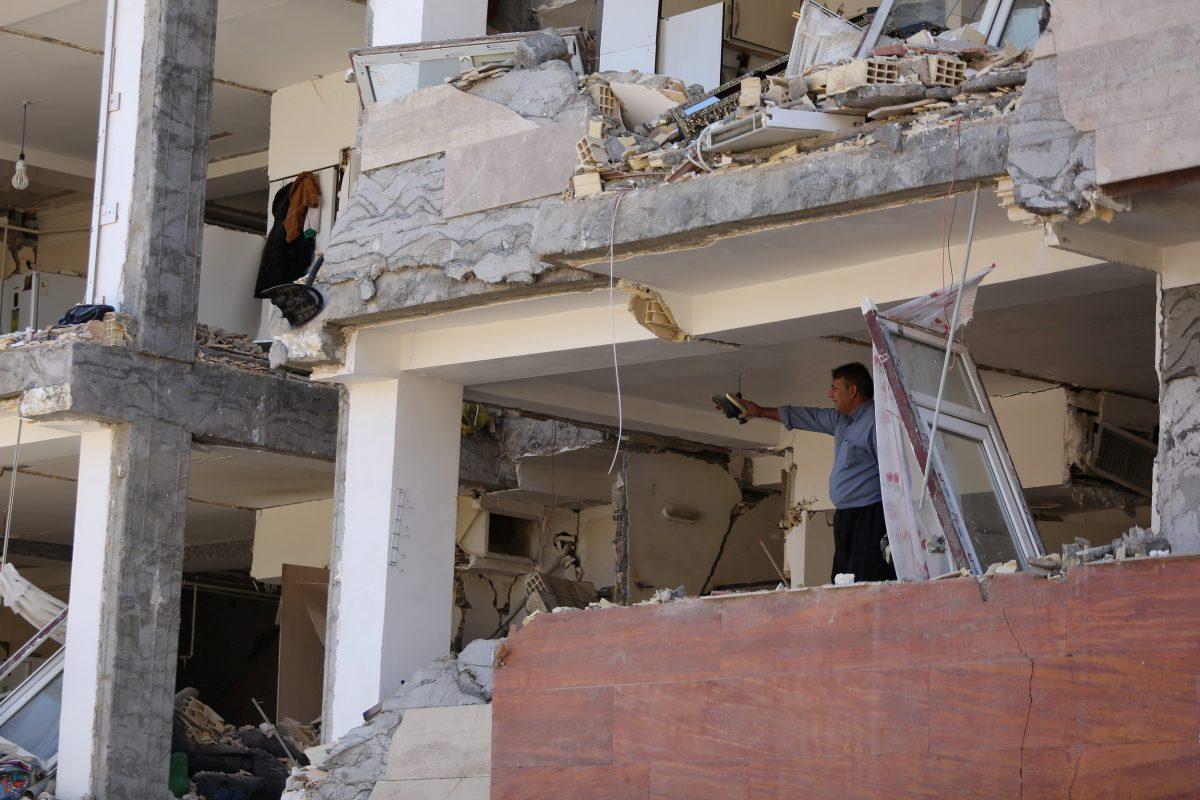 A man gestures inside a damaged building following an earthquake in Sarpol-e Zahab county in Kermanshah, Iran. (REUTERS/Tasnim News Agency)