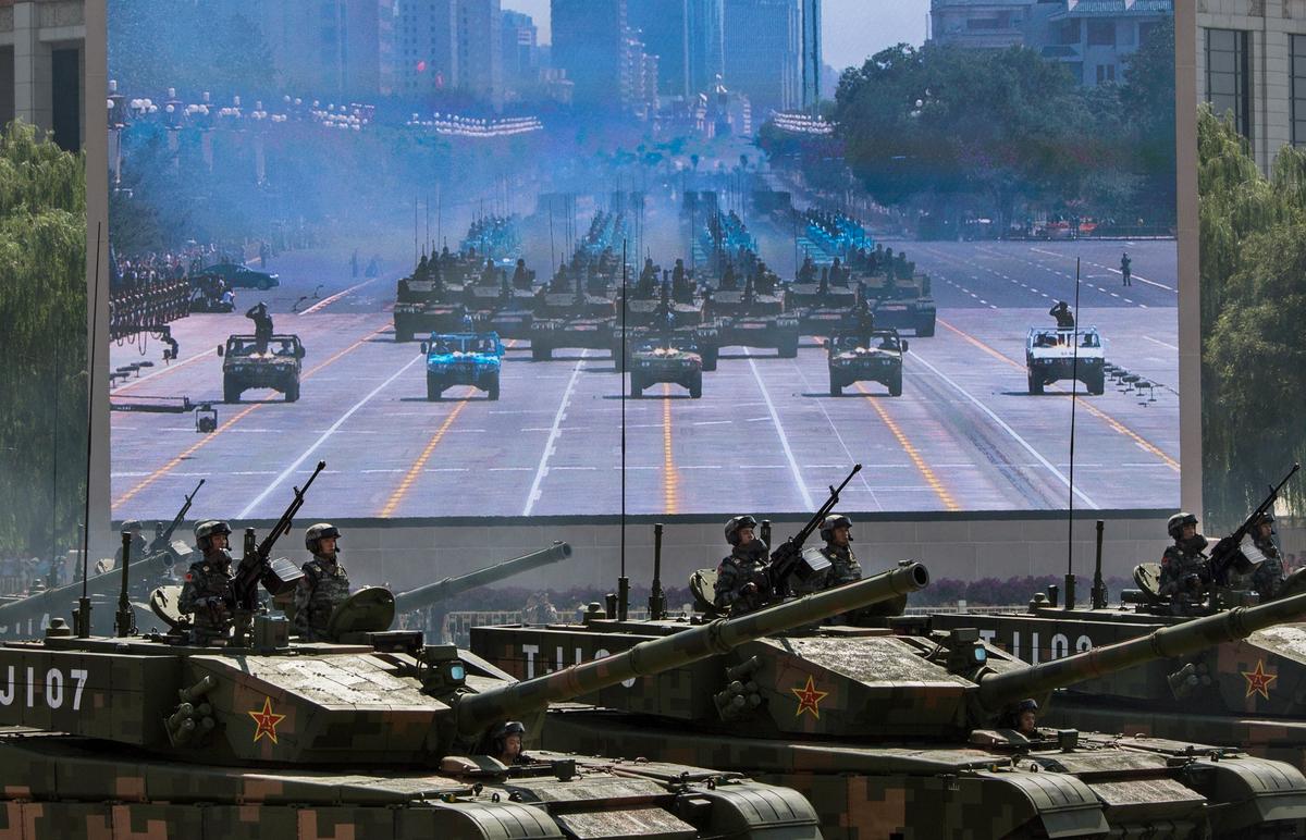 Chinese soldiers ride in tanks as they pass in front of a screen near Tiananmen Square and the Forbidden City during a military parade in Beijing, China, on Sept. 3, 2015. (Kevin Frayer/Getty Images)