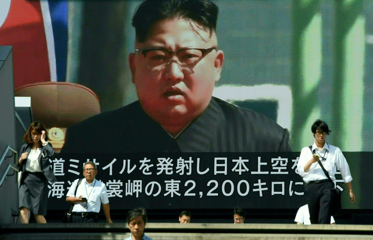 Pedestrians walk in front of a large video screen in Tokyo broadcasting a news report showing North Korean leader Kim Jong-Un, following a North Korean missile test that passed over Japan on September 15, 2017.<br/>(TORU YAMANAKA/AFP/Getty Images)
