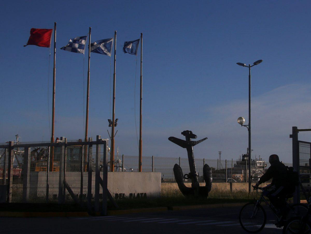 A man rides his bicycle past the entrance of the naval base where the missing at sea ARA San Juan submarine sailed from, in Mar del Plata, Argentina November 18, 2017. (Reuters/Marcos Brindicci)