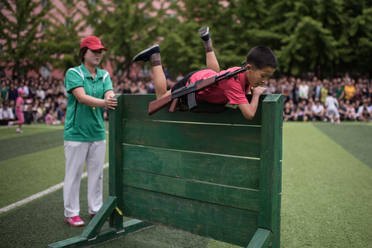 A boy carrying a mock rifle completes an obstacle course as school children take part in sports games marking 'Children's Union Foundation day', in Pyongyang on June 6, 2017. (ED JONES/AFP/Getty Images)
