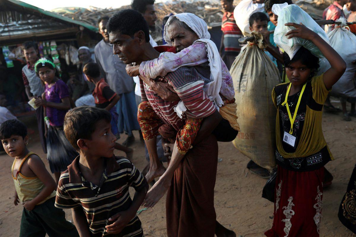 Rohingya refugee Suray Khatun, 70, is carried by her son Said-A-Lam, 38, as they enter Kutupalong refugee camp, near Cox's Bazar, Bangladesh a day after crossing the Burma border, Nov. 20, 2017. (REUTERS/Susana Vera)