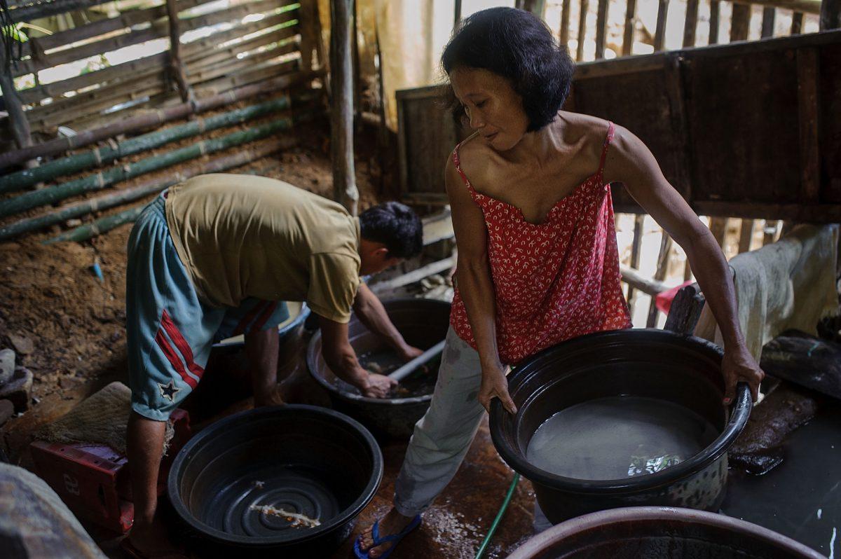 Mill workers move buckets of crushed ore before washing it and adding liquid mercury in order to separate the gold particles from the valueless rock, on April 23, 2014 in Pinut-An, Philippines. (Luc Forsyth/Getty Images)