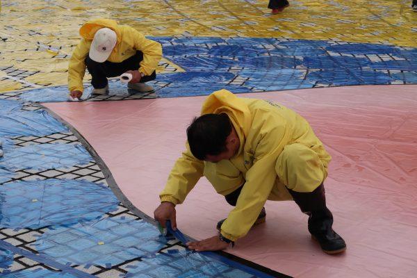 Practitioners of Falun Gong making preparation at Liberty Square in Taipei on Nov. 23, 2017. (Frank Fang/The Epoch Times)