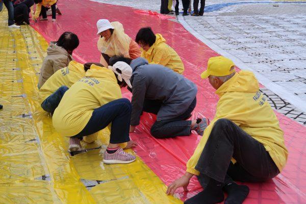 Practitioners of Falun Gong making preparation at Liberty Square on Nov. 23, 2017. (Frank Fang/The Epoch Times)