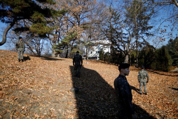 South Korean soldier stand guard next to a spot where a North Korean has defected crossing the border on Nov. 13, as a North Korean guard post (C) is seen at the truce village of Panmunjom inside the demilitarized zone, South Korea, on Nov. 27, 2017. (REUTERS/Kim Hong-Ji)