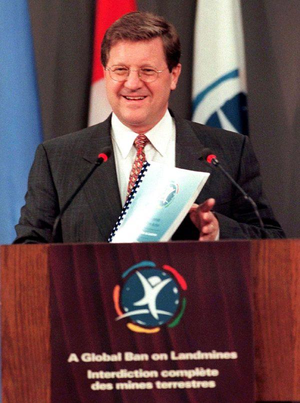 Foreign Affairs minister Lloyd Axworthy holds up a copy of the Mines Action Plan upon the signing of the Anti-Personnel Mine Ban Convention in Ottawa on Dec. 3, 1997. (CP PHOTO/Tom Hanson)