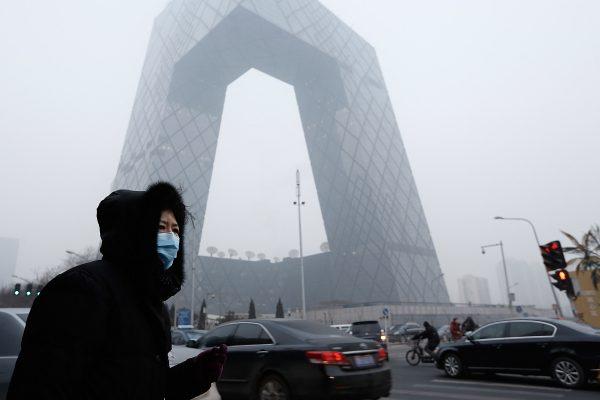 A woman walks past the CCTV Building, the headquarters for the Chinese regime's mouthpiece broadcaster, in Beijing, China on January 23, 2013. (Lintao Zhang/Getty Images)