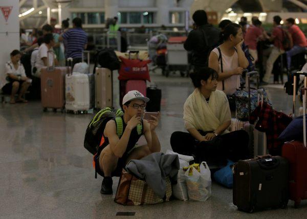 International passengers are seen waiting at the terminal after the airport on the resort island of Bali reopened following the eruption of Mount Agung volcano at Ngurah Rai International Airport, Kuta, Bali, Indonesia Nov. 29, 2017. (Reuters/Johannes P. Christo)