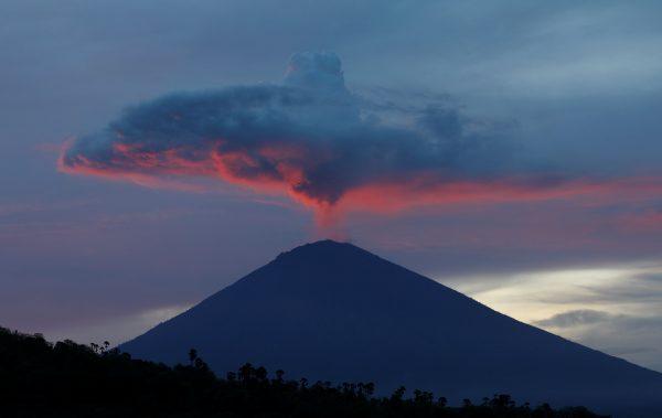 A plume of smoke above Mount Agung volcano is illuminated at sunset as seen from Amed, Karangasem Regency, Bali, Indonesia on Nov. 30, 2017. (Darren Whiteside/Reuters)