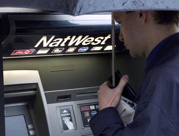 A man uses an ATM outside the NatWest Bank branch on The Strand in central London. (Jonathan Utz/AFP/Getty Images)