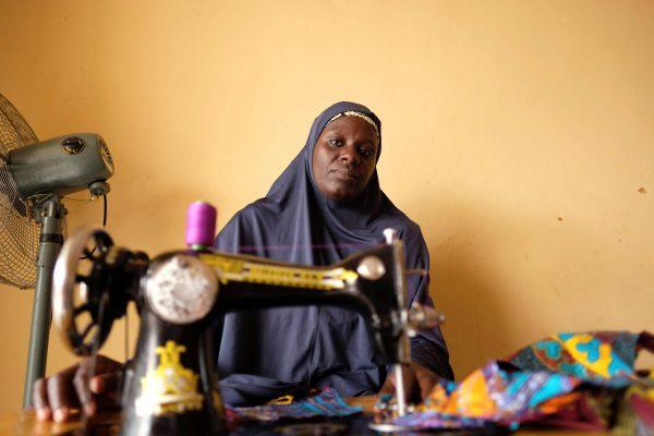 An unidentified internally displaced woman, who sews fabrics to sell, poses for a photograph in a community centre in Bama in northeast Nigeria, November 23, 2017. Picture taken November 23, 2017. (Reuters/Paul Carsten)
